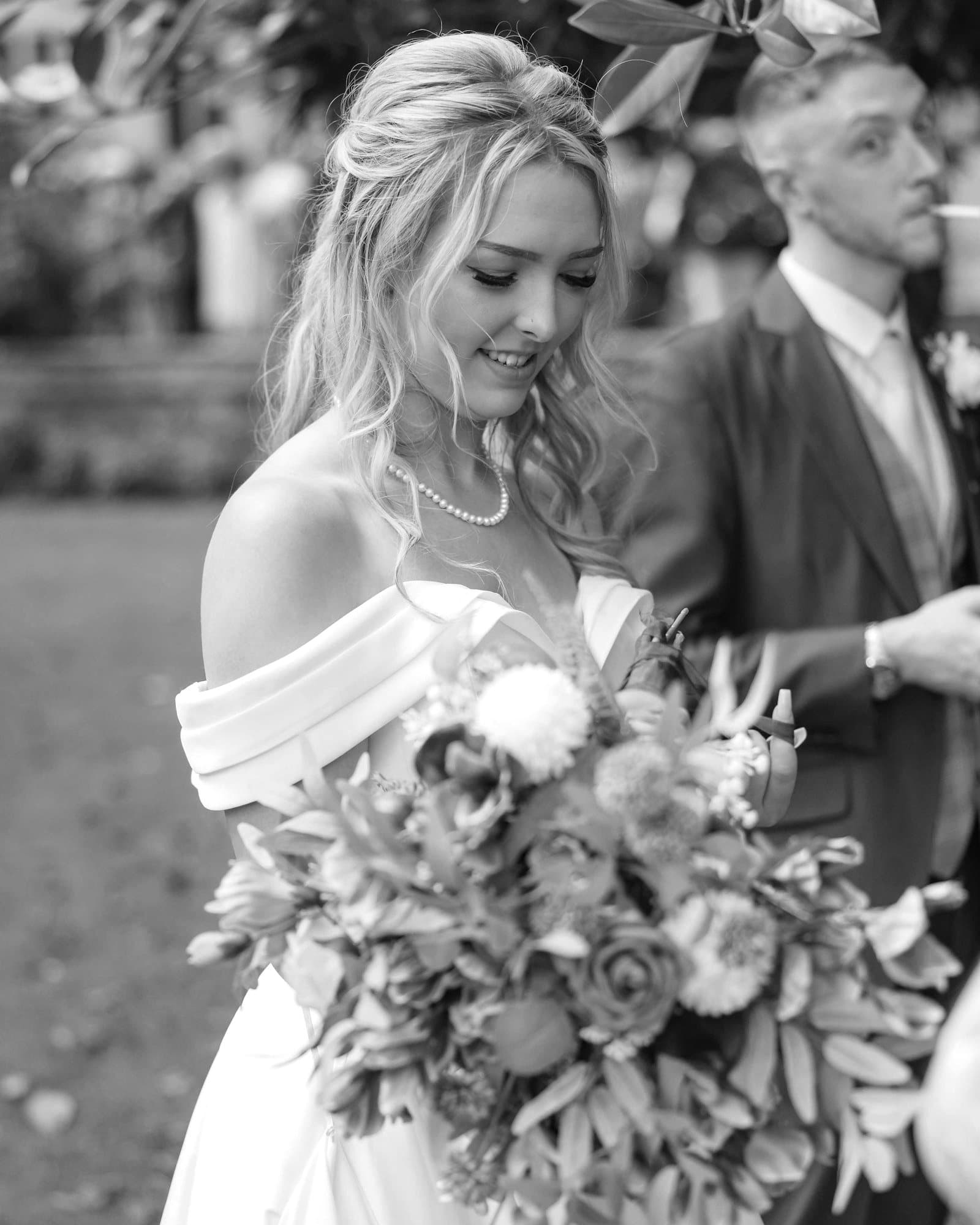 Camille et Antoine côte à côte, la mariée tenant son bouquet