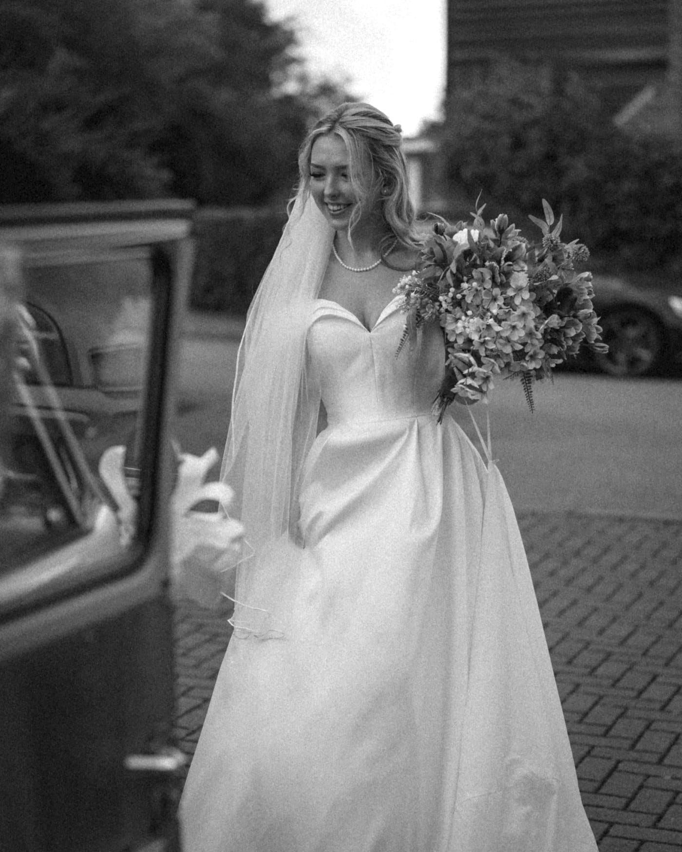 Portrait de la mariée près d’une voiture ancienne